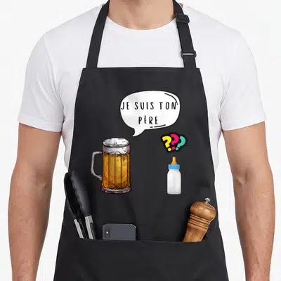 Tablier de cuisine noir avec illustration d'une chope de bière, d'un biberon et la phrase je suis ton père dans une bulle.