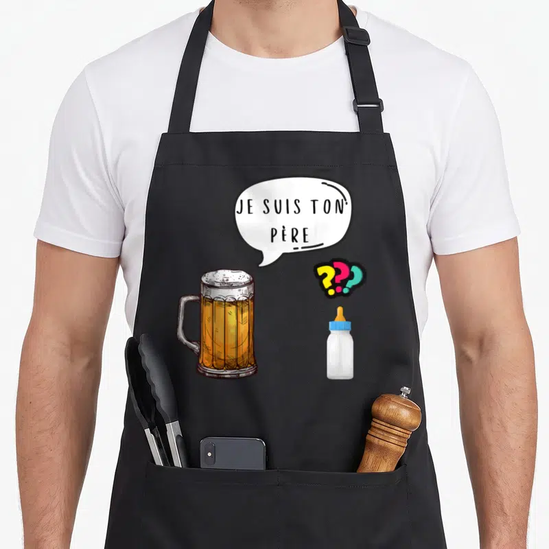 Tablier de cuisine noir avec illustration d'une chope de bière, d'un biberon et la phrase je suis ton père dans une bulle.