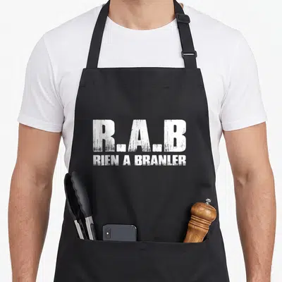 Tablier de cuisine noir avec l'inscription R.A.B et Rien a branler en typographie blanche délavée.