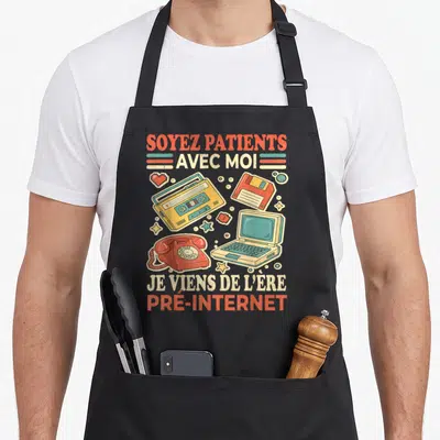 Tablier de cuisine noir avec illustration retro d'un téléphone rotatif, cassette et ordinateur portable ancien.