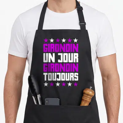 Tablier de cuisine noir avec l'inscription Girondin un jour girondin toujours en violet et blanc entouré d'étoiles.