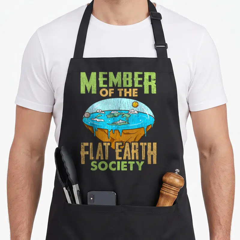 Tablier de cuisine noir avec illustration d'une Terre plate et texte Member of the Flat Earth Society en lettres vertes et oranges.