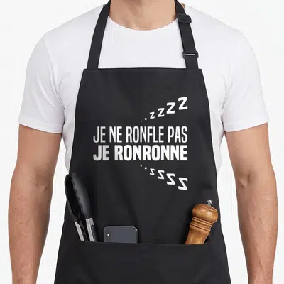 Tablier de cuisine noir avec inscription blanche Je ne ronfle pas je ronronne et symboles Z stylisés.
