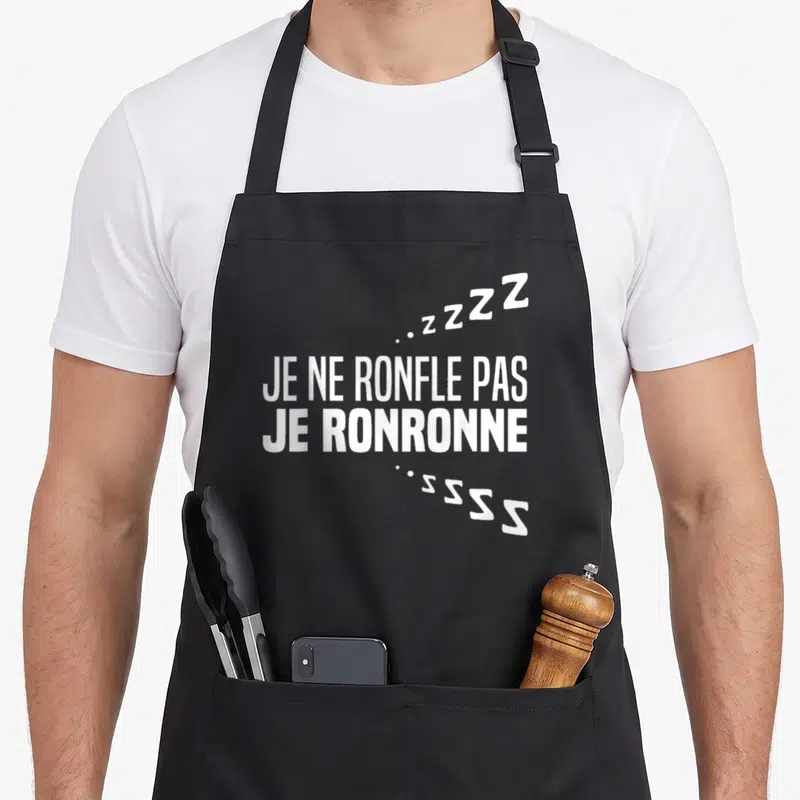 Tablier de cuisine noir avec inscription blanche Je ne ronfle pas je ronronne et symboles Z stylisés.