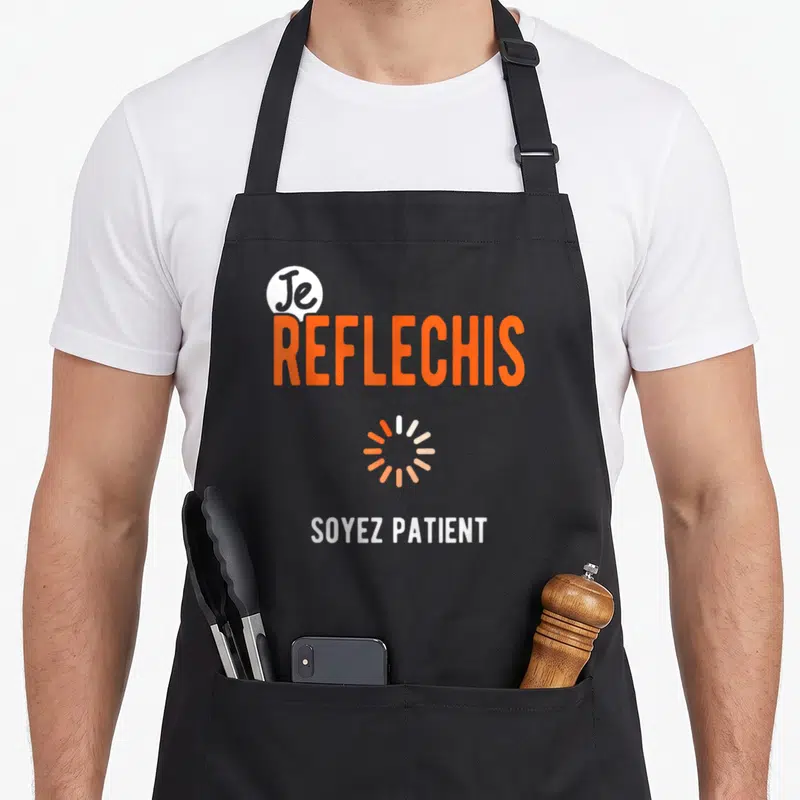 Tablier de cuisine noir avec le texte Je reflechis soyez patient et une icône de chargement circulaire orange.
