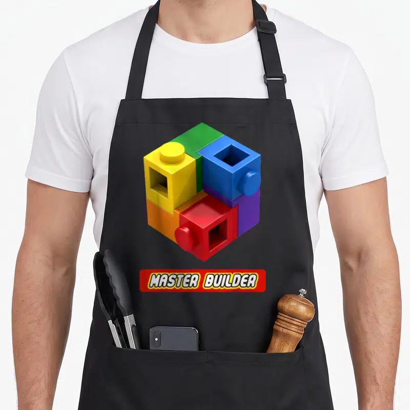 Tablier de cuisine noir avec blocs de construction multicolores et inscription master builder en rouge et blanc.