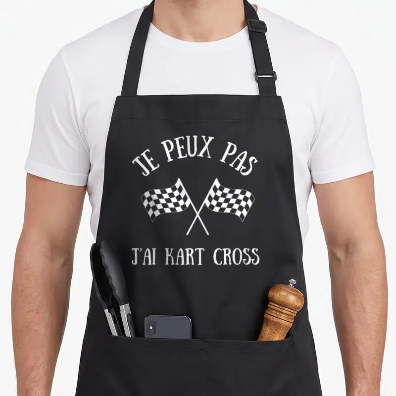 Tablier de cuisine noir avec inscription Je peux pas j'ai kart cross et deux drapeaux damiers blancs croisés.