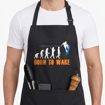 Tablier de cuisine noir avec silhouette évolutive et wakeur bleu sur planche bleue et texte Born to Wake orange