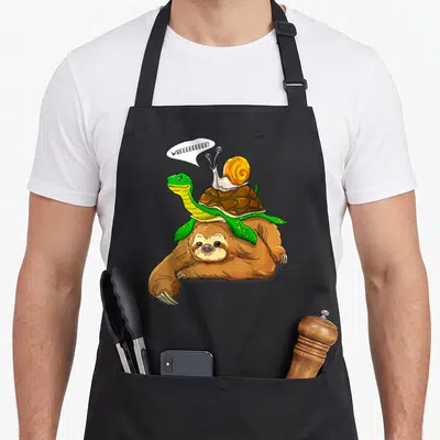 Tablier de cuisine noir avec illustration d'un sloth portant une tortue et un escargot qui crie wheeeee.
