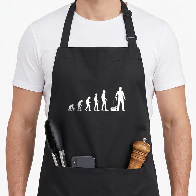 Tablier de cuisine noir avec illustration blanche représentant l'evolution humaine se terminant par un bricoleur tenant une boîte à outils et un outil.