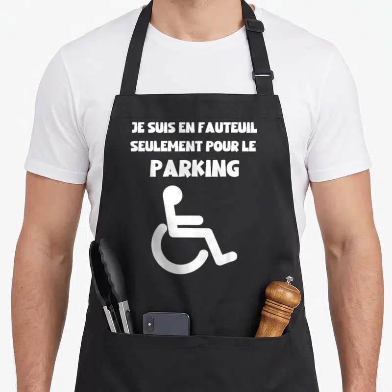 Tablier de cuisine noir avec texte blanc je suis en fauteuil seulement pour le parking et un pictogramme de fauteuil roulant.