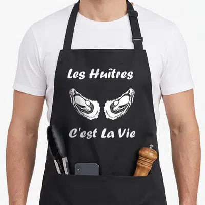 Tablier de cuisine noir avec deux huîtres ouvertes et le texte les huitres c'est la vie imprimé en blanc au centre.