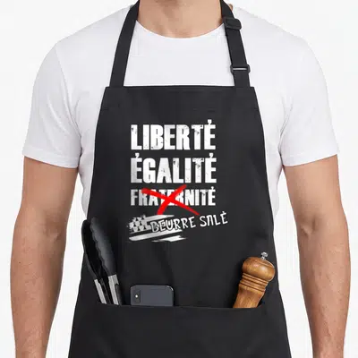 Tablier de cuisine noir avec texte blanc Liberté Égalité Beurre Salé et drapeau breton stylisé.