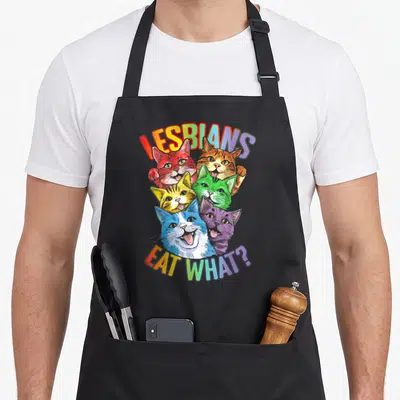 Tablier de cuisine noir avec six chats colorés et le texte Lesbians Eat What en arc-en-ciel.