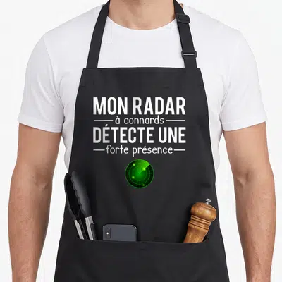Tablier de cuisine noir avec inscription blanche Mon radar à connards détecte une forte présence et un écran radar vert en bas.