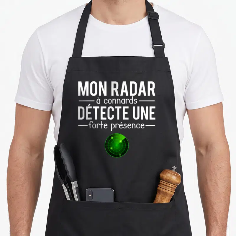 Tablier de cuisine noir avec inscription blanche Mon radar à connards détecte une forte présence et un écran radar vert en bas.