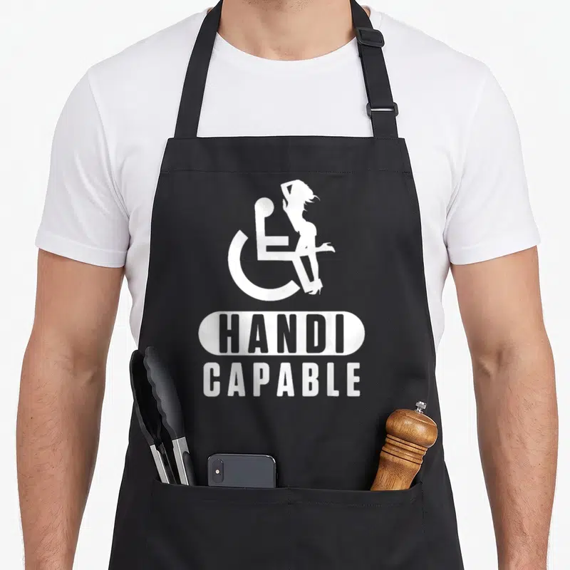 Tablier de cuisine noir avec logo blanc handi capable et silhouette féminine assise sur le symbole de accessibilité