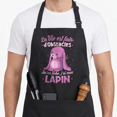 Tablier de cuisine noir avec illustration d'un lapin rose et texte La Vie est faite d'obstacles Im'en fiche j'ai mon lapin