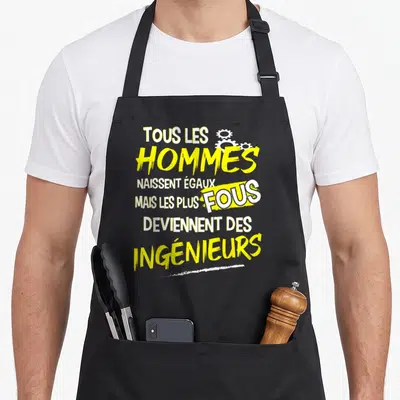 Tablier de cuisine noir avec inscription jaune et blanche Tous les hommes naissent égaux mais les plus fous deviennent des ingénieurs et troiss blancs.