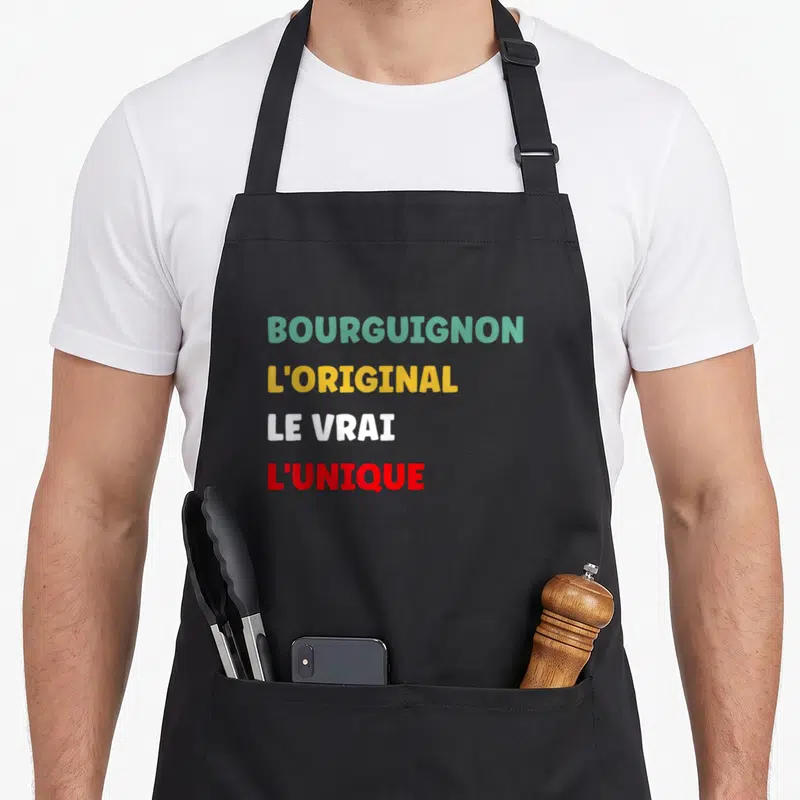 Tablier de cuisine noir avec inscription colorée Bourguignon L'original Le Vrai L'unique en lettres capitales.