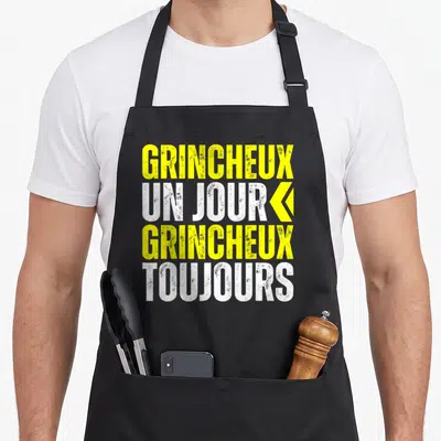 Tablier de cuisine noir avec linscription grincheux un jour grincheux toujours en jaune et blanc.