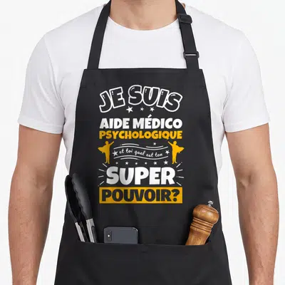 Tablier de cuisine noir avec inscription Je suis aide médico psychologique et toi quel est ton super pouvoir en blanc et orange.