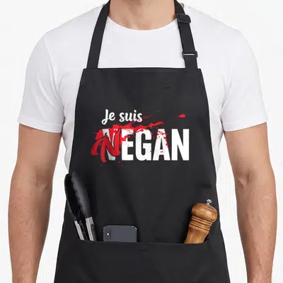 Tablier de cuisine noir avec le texte Je suis vegan en blanc et éclaboussures rouges.