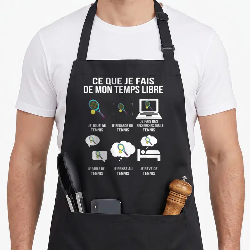 Tablier de cuisine noir avec illustration humoristique sur le tennis et des icônes colorées.