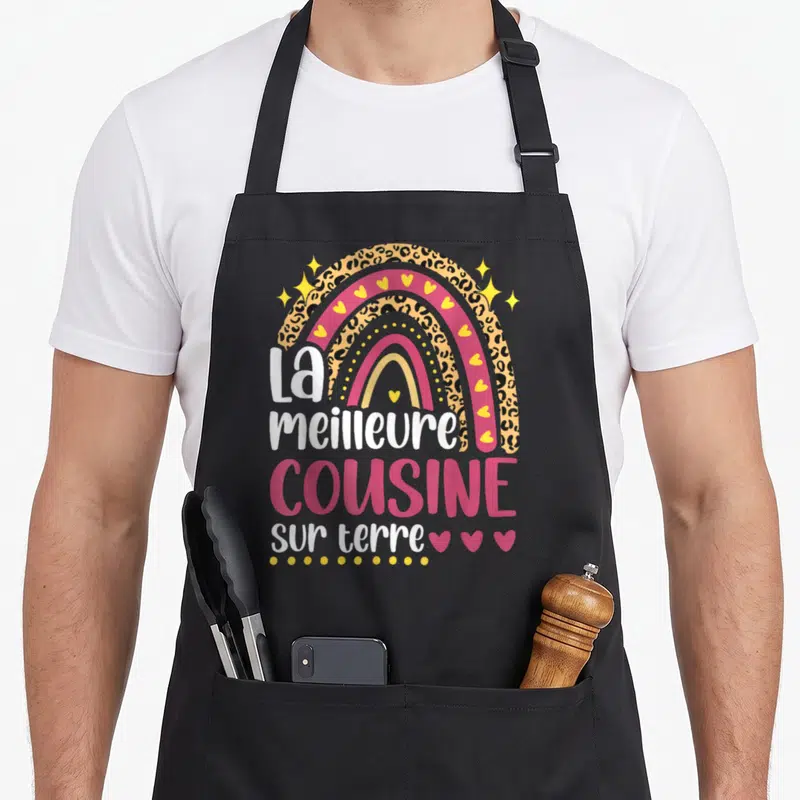 Tablier de cuisine noir avec un arc en ciel coloré, motif léopard et texte La meilleure cousine sur terre