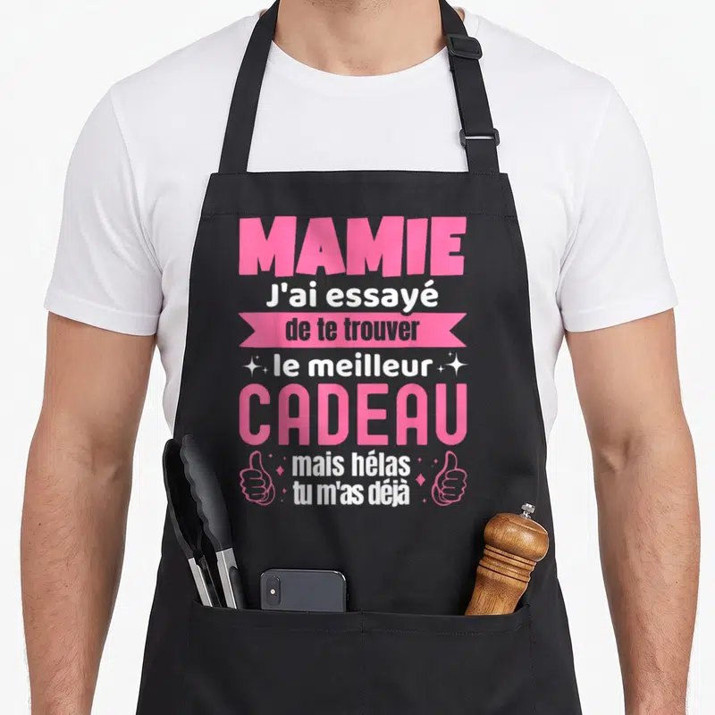 Tablier de cuisine noir avec inscription rose et blanche Mamie J'ai essayé de te trouver le meilleur cadeau mais hélas tu m'as déjà entouré de mains et d'étoiles.