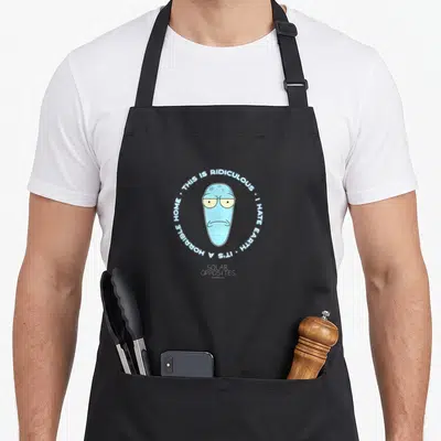 Tablier de cuisine noir avec illustration ronde de Korvo et texte circulaire blanc sur fond gris uni.