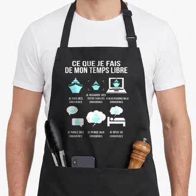 Tablier de cuisine noir avec illustration bleue et blanche représentant un navire de croisière et des icônes liées aux loisirs maritimes.