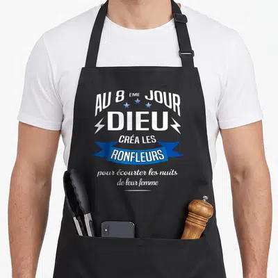 Tablier de cuisine noir avec inscription blanche et bleue sur le thème des ronfleurs et de l'humour matrimonial.