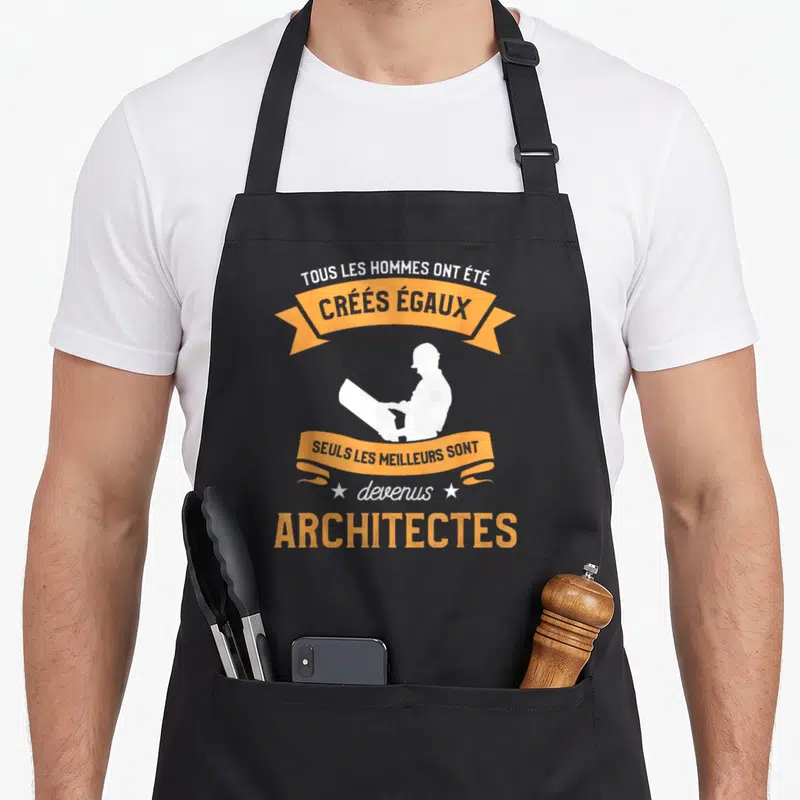 Tablier de cuisine noir avec silhouette architecte et banderoles oranges citant la phrase Créés Égaux Architectes.