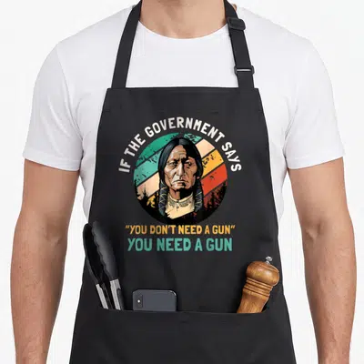 Tablier de cuisine noir avec portrait style vintage et texte If The Government Says You Don't Need A Gun You Need A Gun