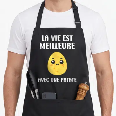 Tablier de cuisine noir avec une patate jaune souriante et le texte La vie est meilleure avec une patate imprimé en blanc.