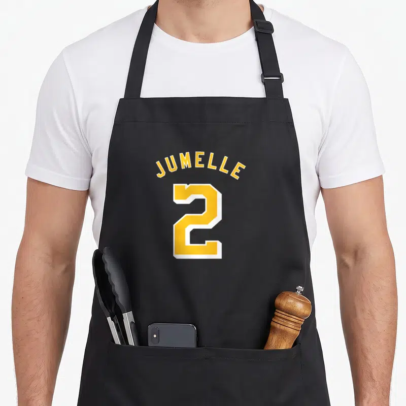 Tablier de cuisine noir avec l'inscription Jumelle 2 en maillot sportif jaune et blanc.