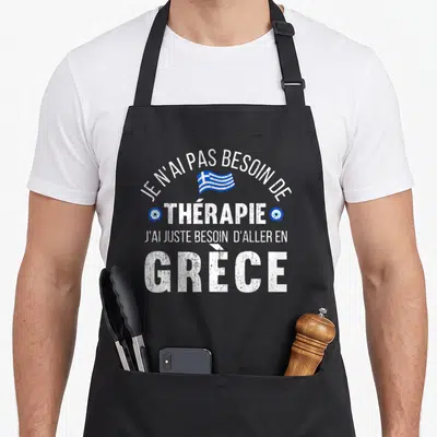 Tablier de cuisine noir avec texte blanc et drapeau bleu de la Grèce au centre du motif imprimé.