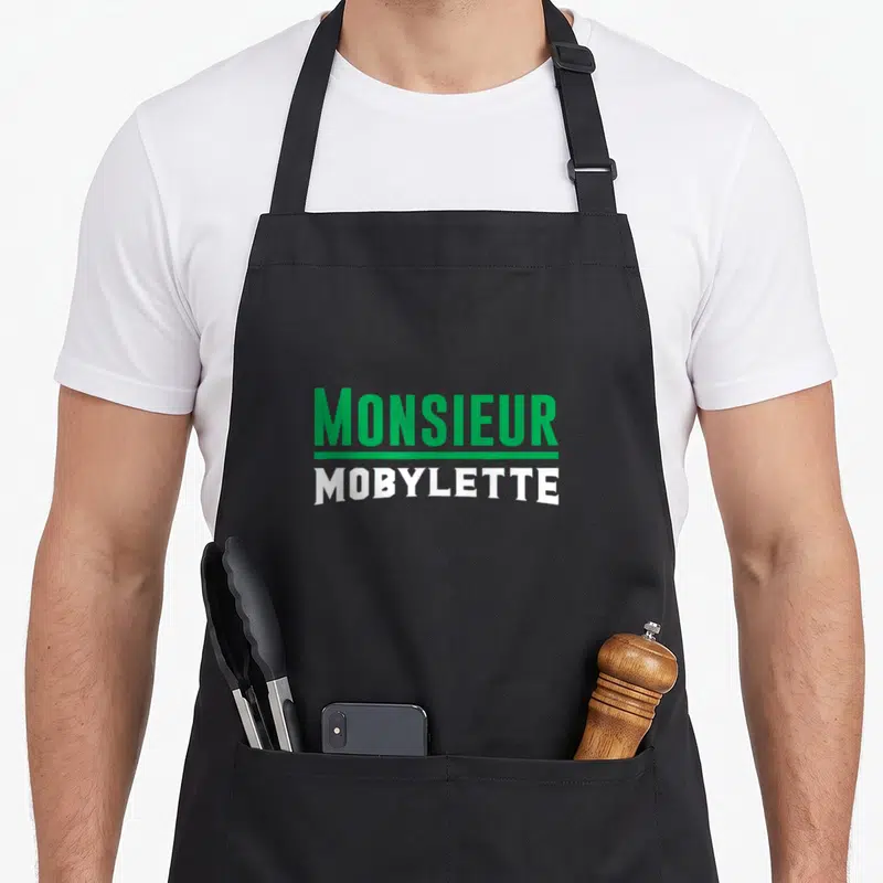 Tablier de cuisine noir avec l'inscription Monsieur Mobylette en vert et blanc au centre du torse.