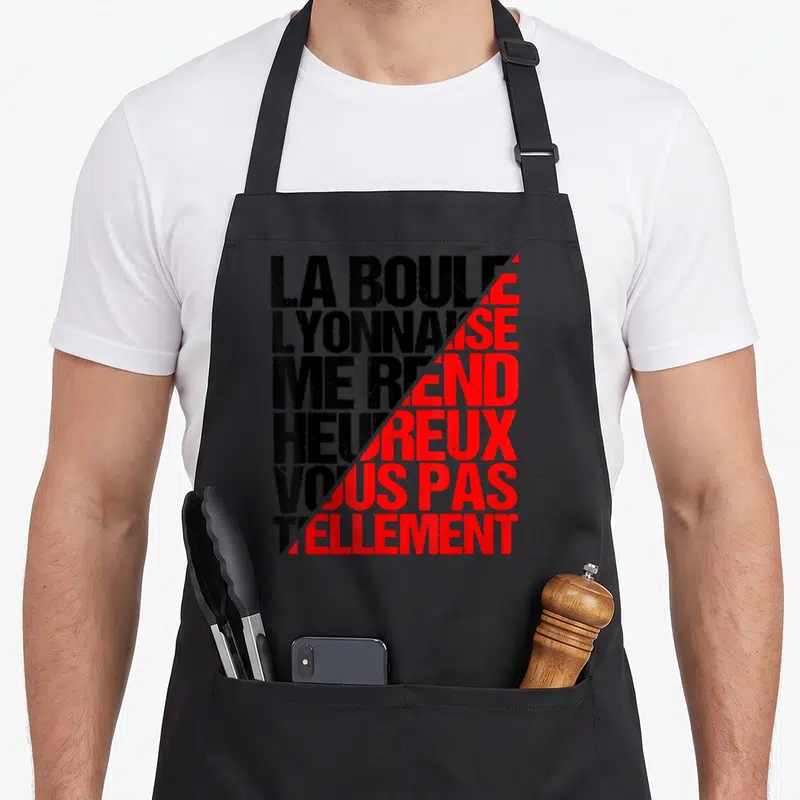 Tablier de cuisine noir avec inscription typographique noire et rouge La boule lyonnaise me rend heureux vous pas tellement.