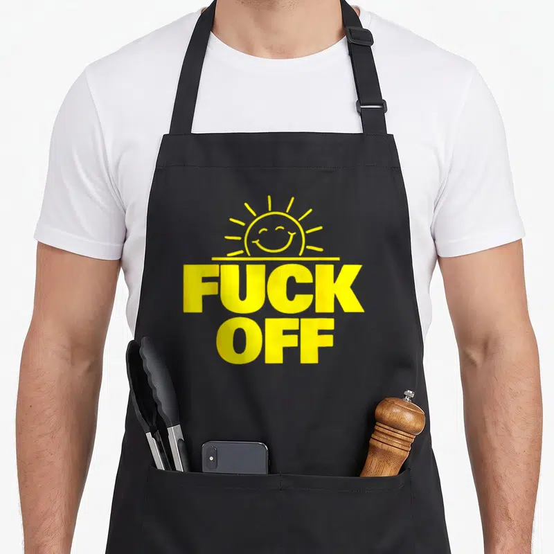Tablier de cuisine noir avec inscription jaune Fuck Off sous un soleil souriant stylisé.