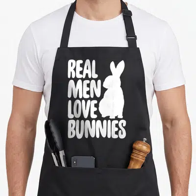 Tablier de cuisine noir avec silhouette de lapin blanc et texte real men love bunnies imprimé en lettres capitales.