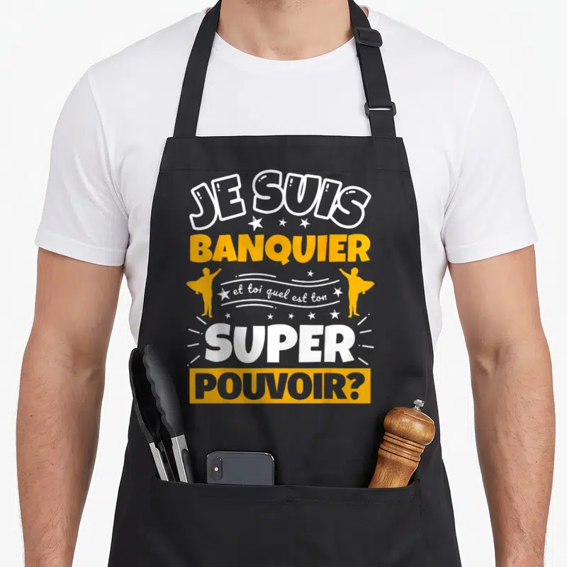 Tablier de cuisine noir avec texte Je suis banquier et toi quel est ton super pouvoir en jaune et blanc.