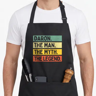 Tablier de cuisine noir avec inscription Daron the man the myth the legend sur bandes colorées horizontales vintage.