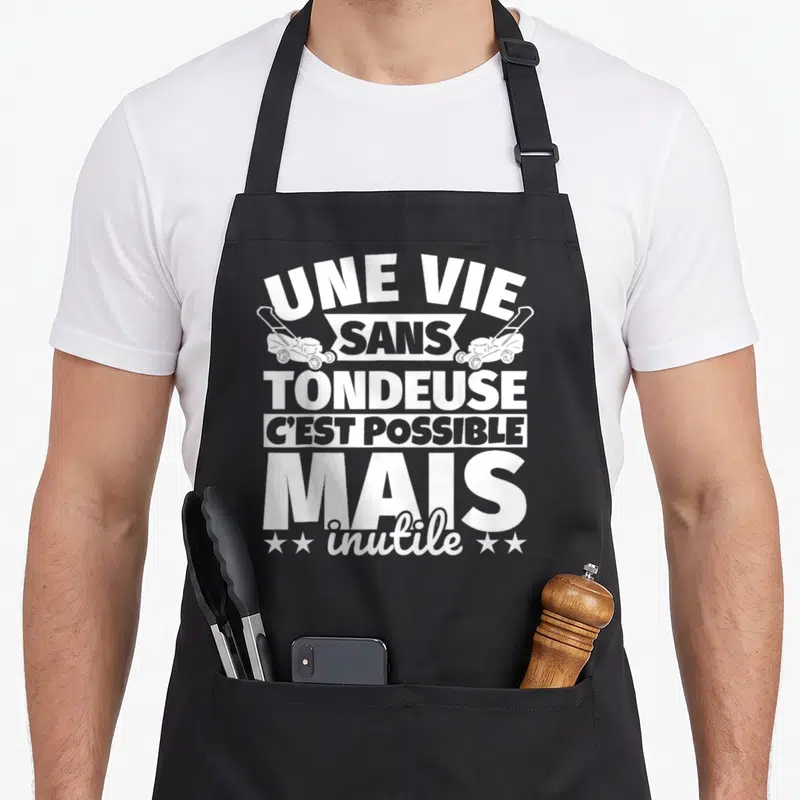 Tablier de cuisine noir avec inscription blanche sur la tondeuse et deux petites illustrations de machines de jardinage.