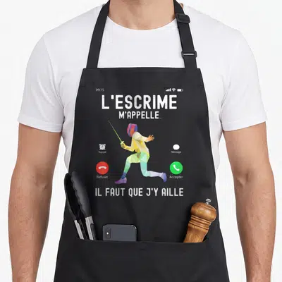 Tablier de cuisine noir avec escrimeur géométrique tenant une épée verte et texte blanc sur fond gris.