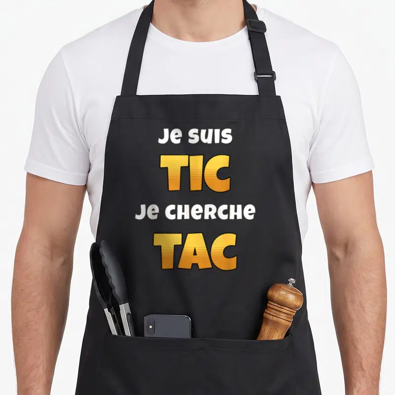 Tablier de cuisine noir avec l'inscription Je suis TIC Je cherche TAC en typographie orange et blanche.