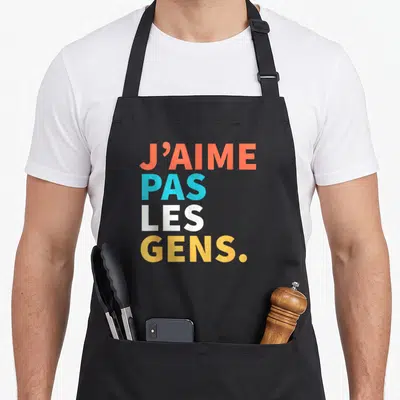 Tablier de cuisine noir avec inscription J'AIME PAS LES GENS en lettres colorées orange, bleu et jaune.