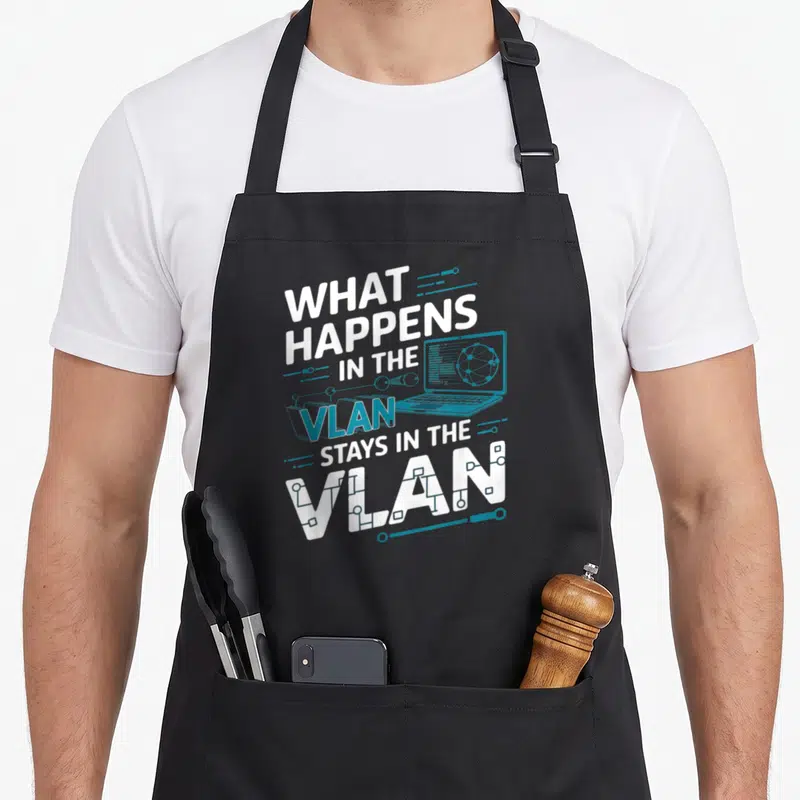 Tablier de cuisine noir avec inscription What Happens in the VLAN et illustration ordinateur portable bleue.