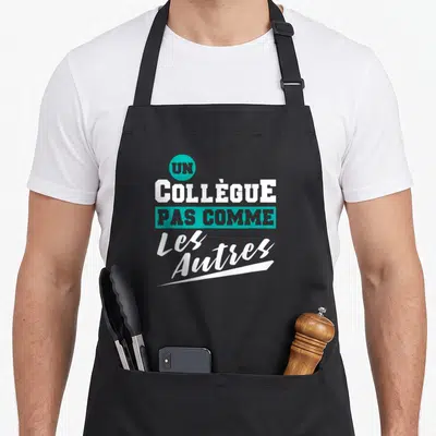 Tablier de cuisine noir avec l'inscription un collègue pas comme les autres en blanc et turquoise.